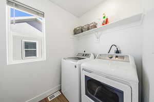 Laundry room featuring washer and clothes dryer and wood finished floors