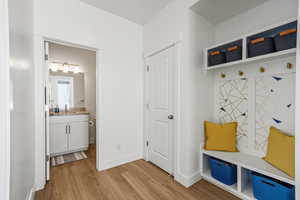 Mudroom with light wood-style flooring and baseboards