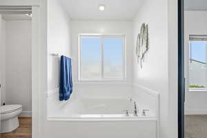 Full bath featuring a bath and toilet