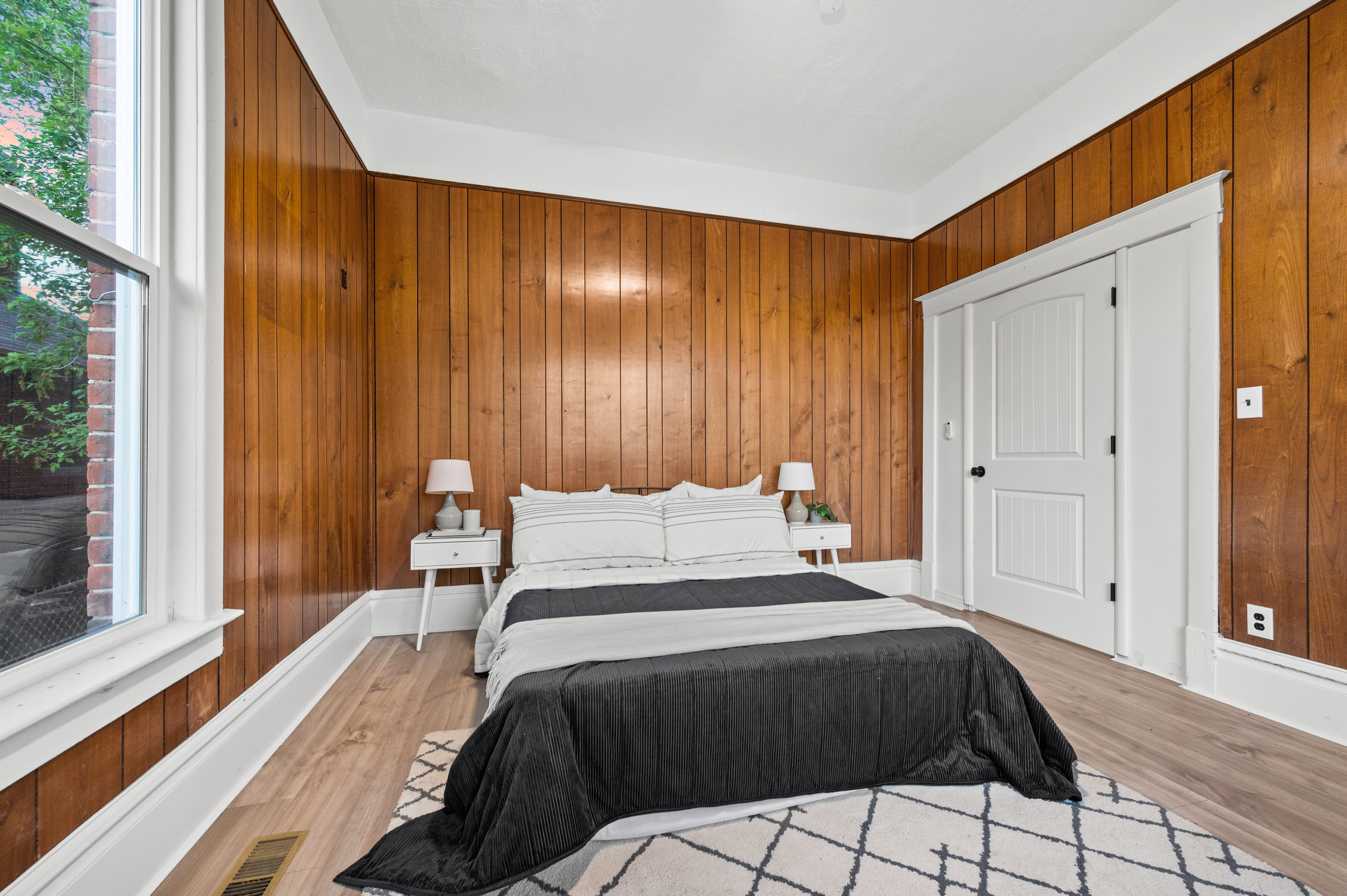 Wood-paneled room featuring light wood-finish flooring