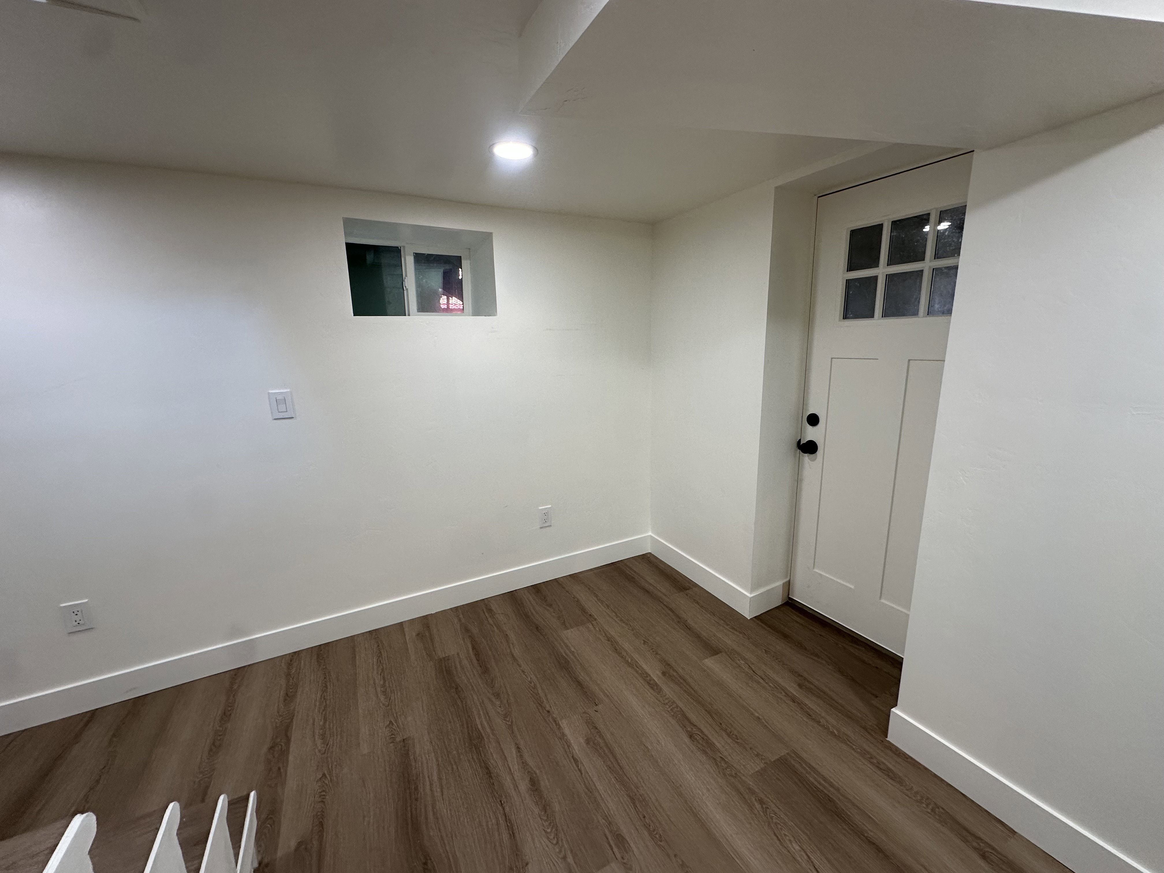 Finished basement with dark wood-style flooring and recessed lighting