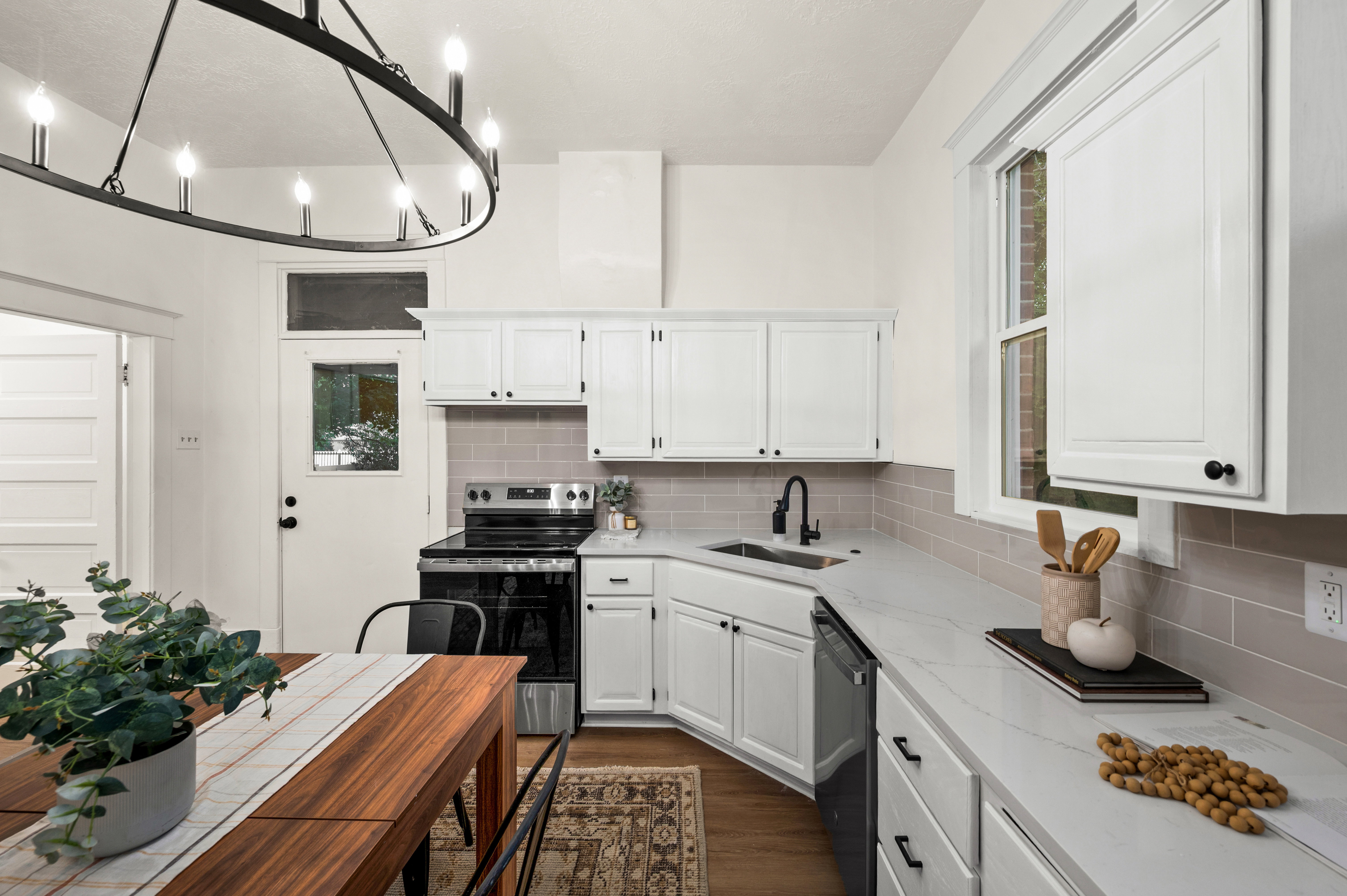 Kitchen featuring white cabinetry, light gray subway tile backsplash, and light-toned countertops