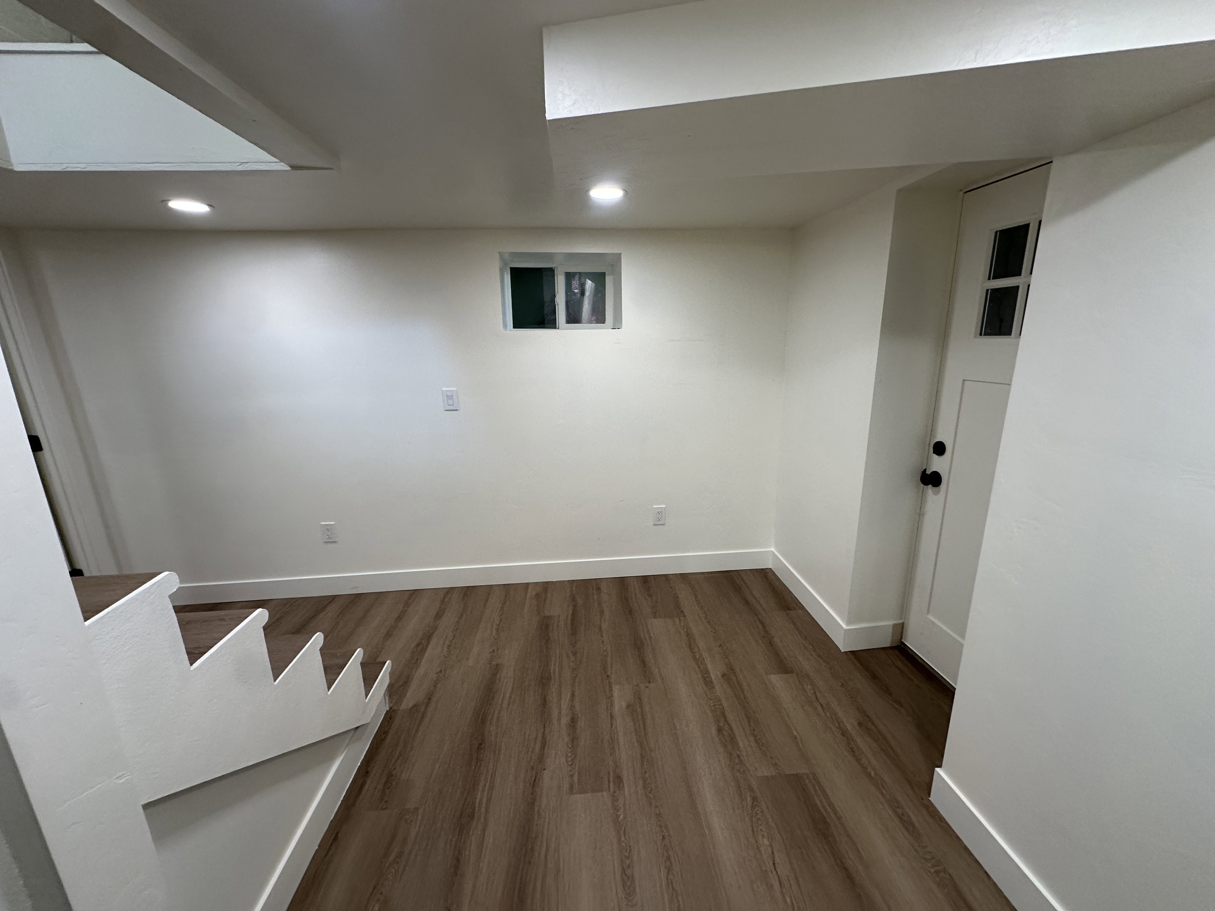 Finished below grade area with dark wood-style floors and recessed lighting