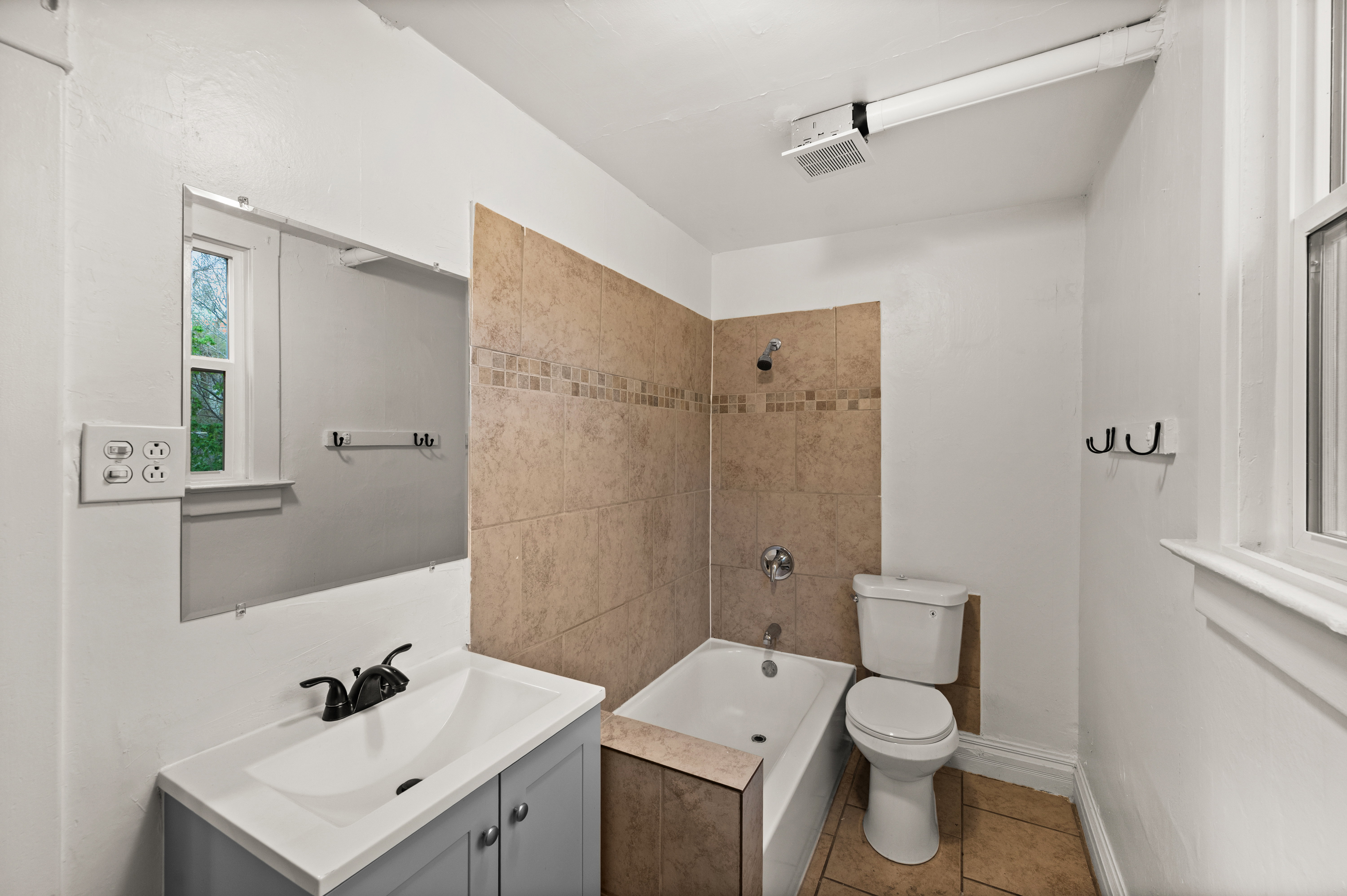 Bathroom with vanity,  shower combination, and light tile patterned flooring