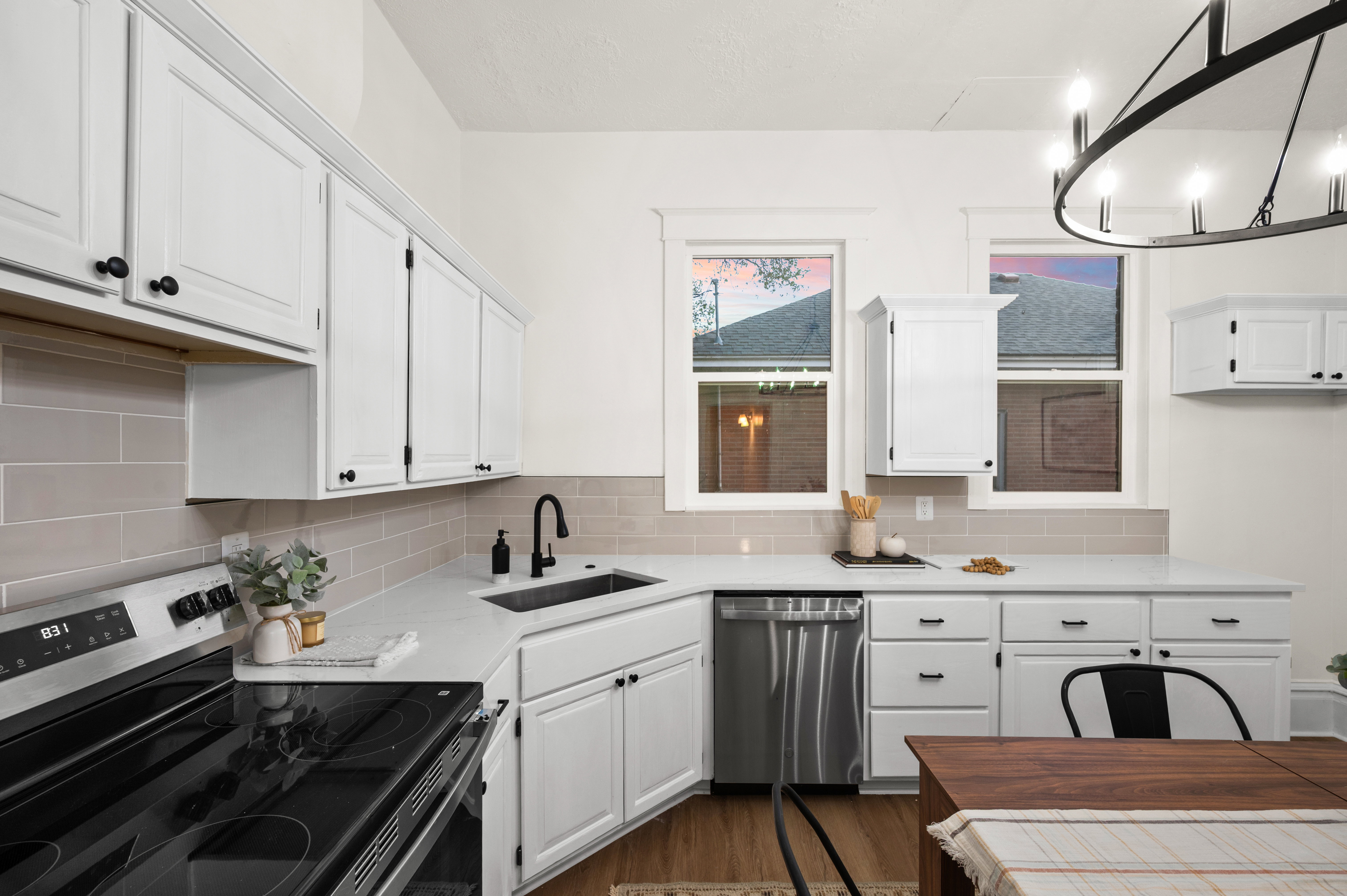 Kitchen featuring white cabinetry with black hardware, white countertops, and a light gray subway tile backsplash