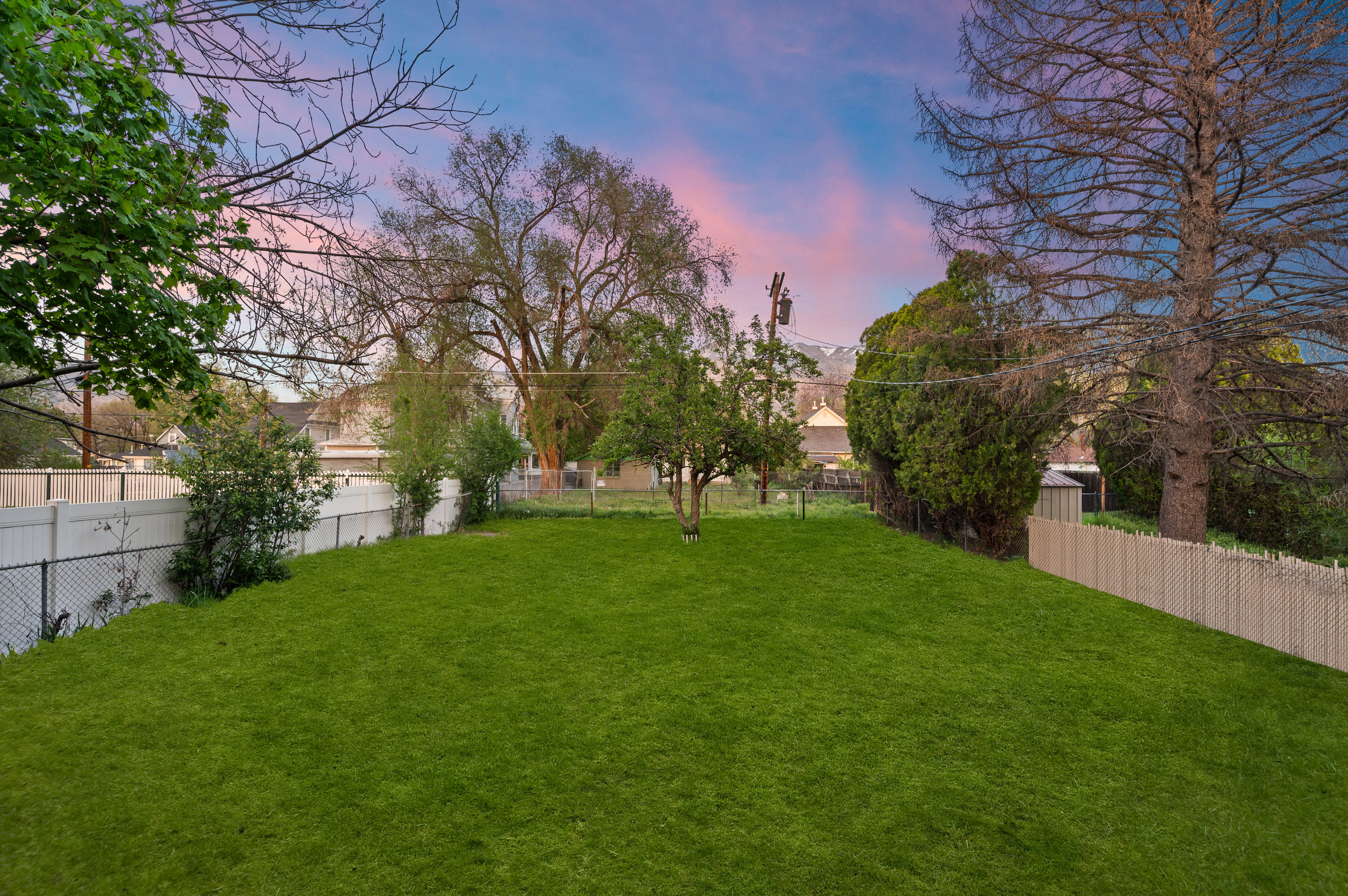 Photos of lawn are digitally enhanced. Yard at dusk featuring a fenced backyard and access to alleyway. Garage could be added