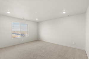 Empty room featuring light carpet and recessed lighting