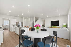 Dining room with light wood-style floors and recessed lighting