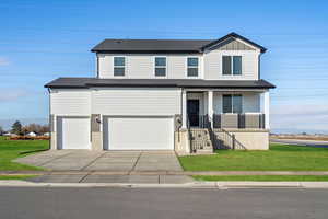 **DISCLAIMER** Grass not included. View of front of house featuring covered porch, a front lawn, concrete driveway, an attached garage, and board and batten siding