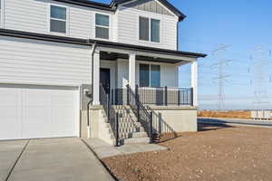 View of front of home with a porch, board and batten siding, a garage, and driveway