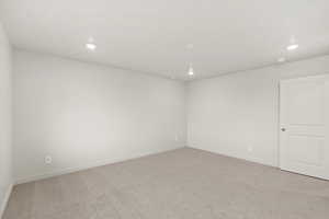 Unfurnished room with light colored carpet and recessed lighting