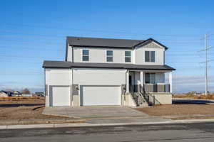 View of front facade featuring covered porch, concrete driveway, a shingled roof, an attached garage, and board and batten siding