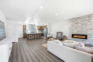 Living room with dark wood-style flooring, a fireplace, and recessed lighting