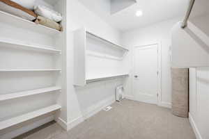 Walk in closet with light carpet