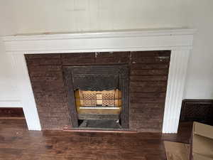 Detailed view of wood finished floors and a fireplace