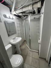 Bathroom with a stall shower and light tile patterned flooring