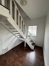Stairs with wood finished floors and baseboards