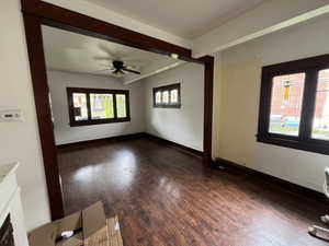 Empty room featuring dark wood-style floors and a ceiling fan