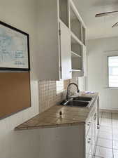Kitchen featuring tile counters, a ceiling fan, and white cabinets