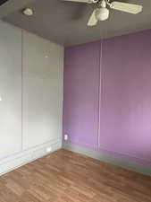 Unfurnished room featuring ceiling fan, wood finished floors, and a smoke detector