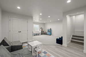 Living area with light wood-style floors, recessed lighting, and a textured ceiling