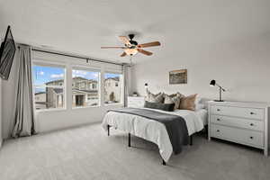 Bedroom with light colored carpet and a ceiling fan
