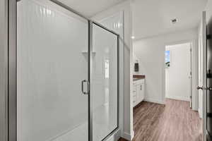 Full bath with vanity, a stall shower, dark wood finished floors, and recessed lighting