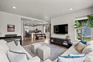 Living area featuring dark wood-type flooring and recessed lighting