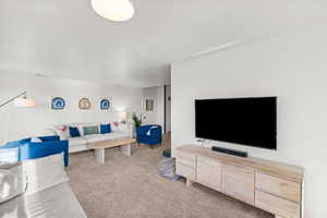 Living area featuring light carpet