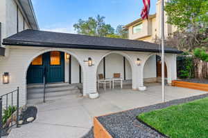 Doorway to property featuring roof with shingles and covered porch