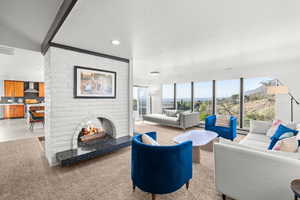Living area with light colored carpet, a fireplace, recessed lighting, a textured ceiling, and beam ceiling