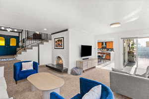 Living area with carpet, a fireplace, and a textured ceiling