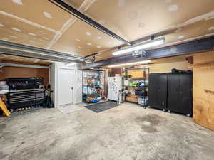 Garage with freestanding refrigerator and a garage door opener