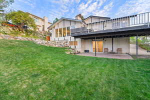 Rear view of property featuring a yard and a patio area