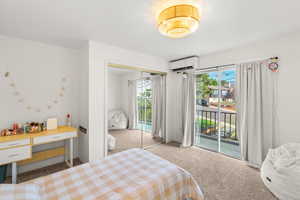 Bedroom with light carpet, access to exterior, a closet, and multiple windows