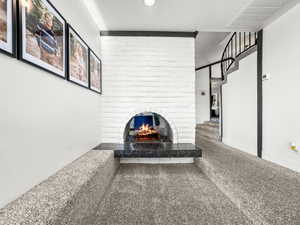 Living area with a brick fireplace and carpet floors