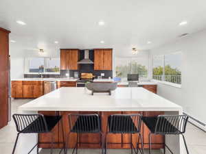 Kitchen with wood finish cabinetry, a kitchen bar, a kitchen island, decorative backsplash, and recessed lighting