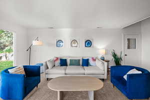 Living room with carpet flooring and a textured ceiling