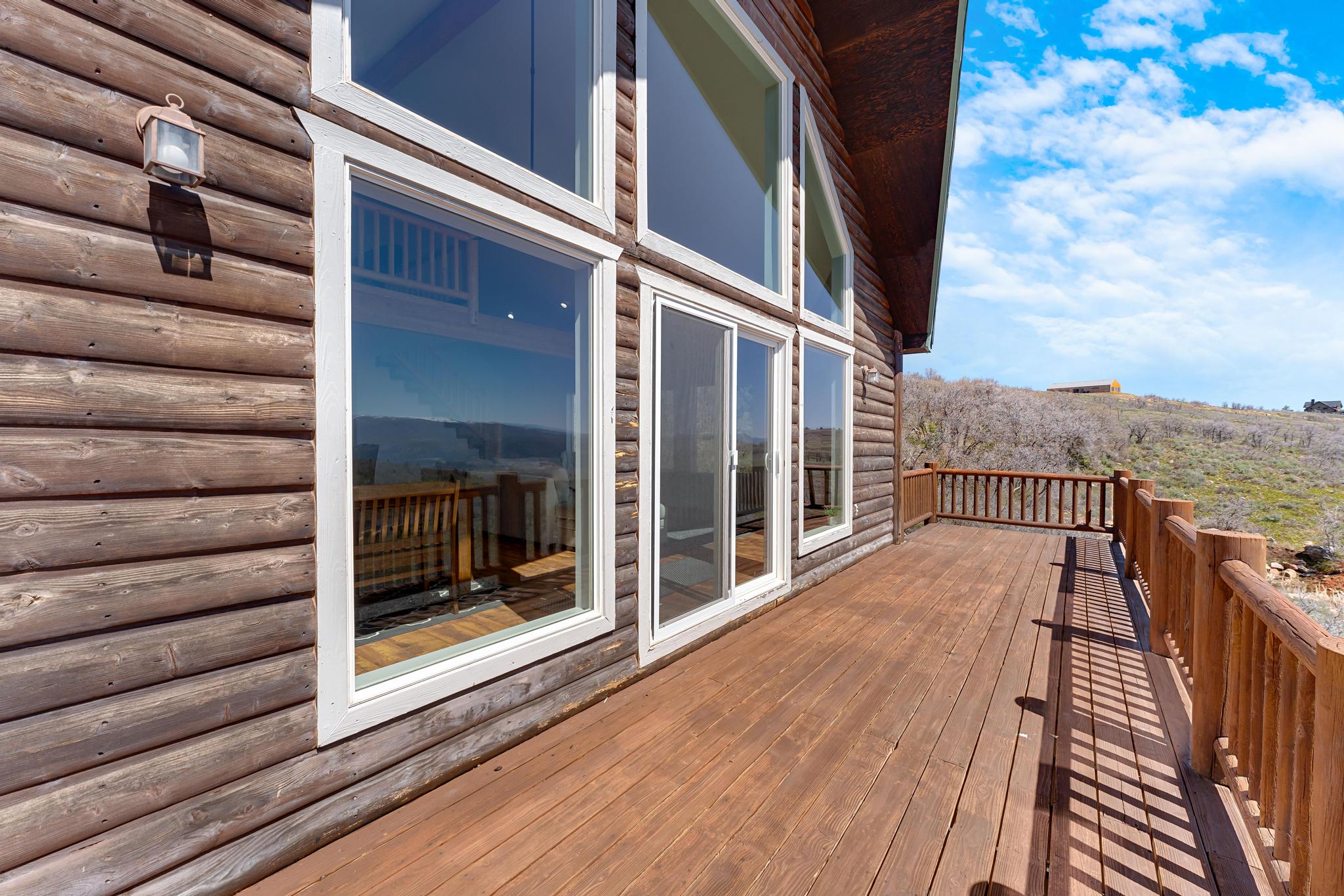 Expansive outdoor deck featuring wood flooring and matching wood railing