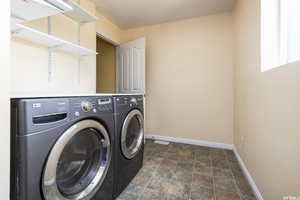 Laundry room featuring stone finish floors and separate washer and dryer