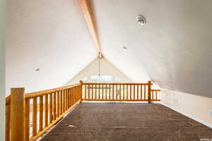 Bonus room with beamed ceiling, carpet flooring, and a textured ceiling
