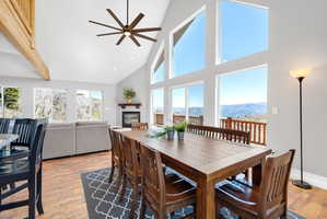 Great room featuring soaring vaulted ceilings, a prominent exposed beam, and large picture windows framing distant mountain scenery