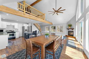 Vaulted great room featuring wood-finish flooring, a contemporary ceiling fan, and abundant natural light from multiple windows