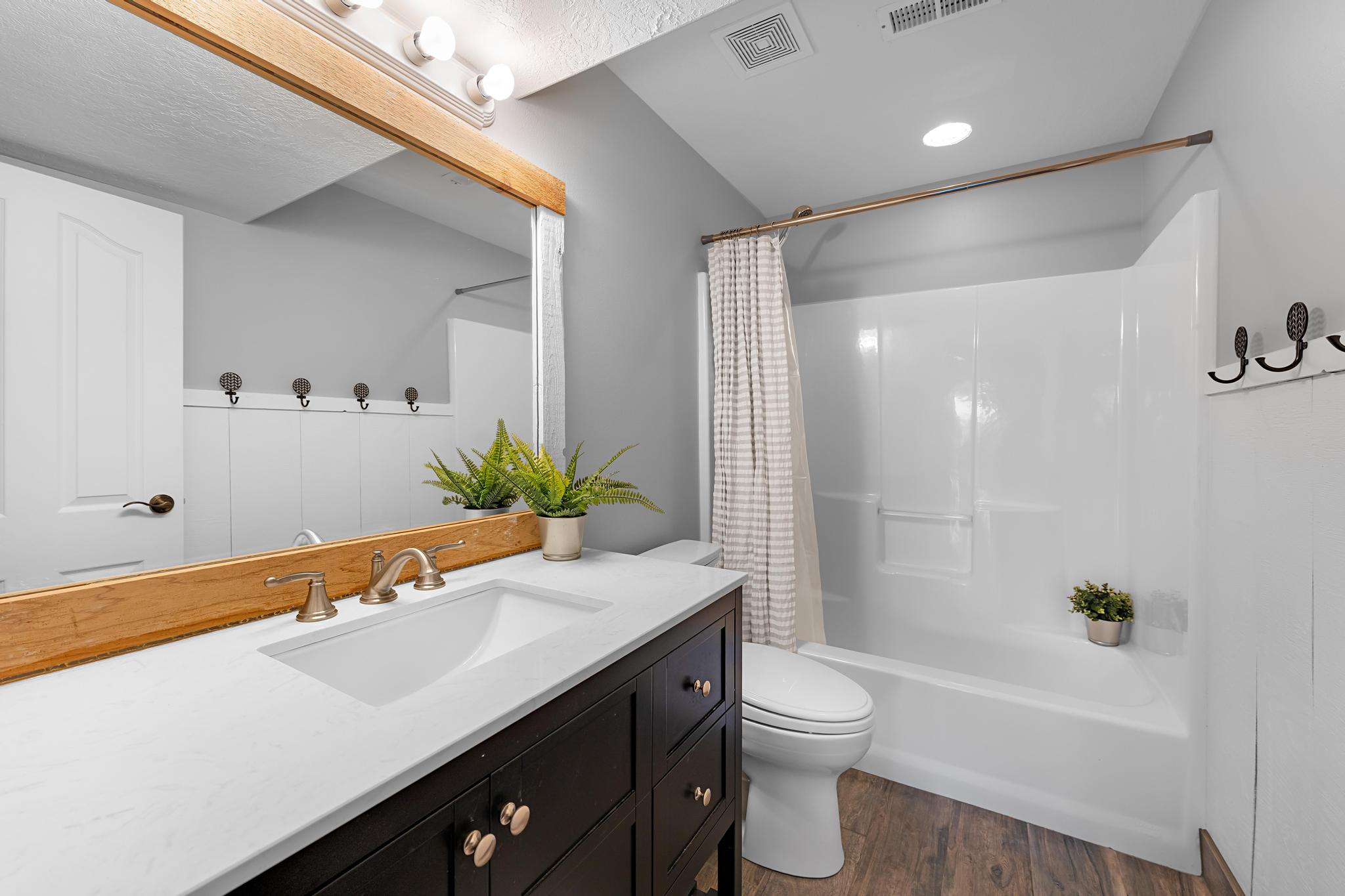 Bathroom featuring a dark wood-finish vanity with a white countertop and an integrated sink
