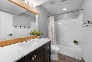Bathroom featuring a dark wood-finish vanity with a white countertop and an integrated sink