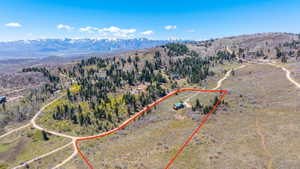 Expansive property outlined in red, featuring a single dwelling amidst natural terrain and scattered trees
