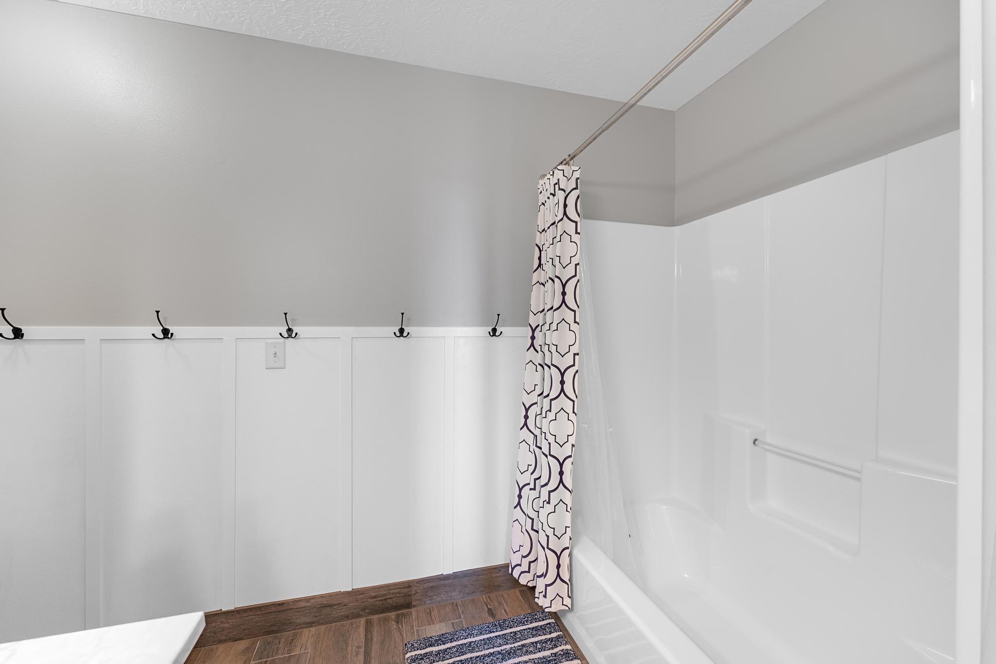 Full bathtub and shower combination with white surround