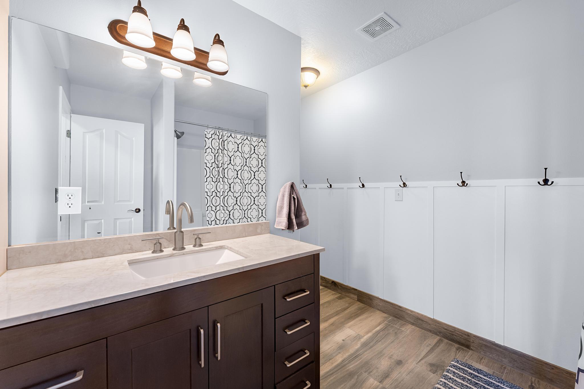 Bathroom featuring a dark wood-finish vanity with a light-toned countertop and an undermount sink