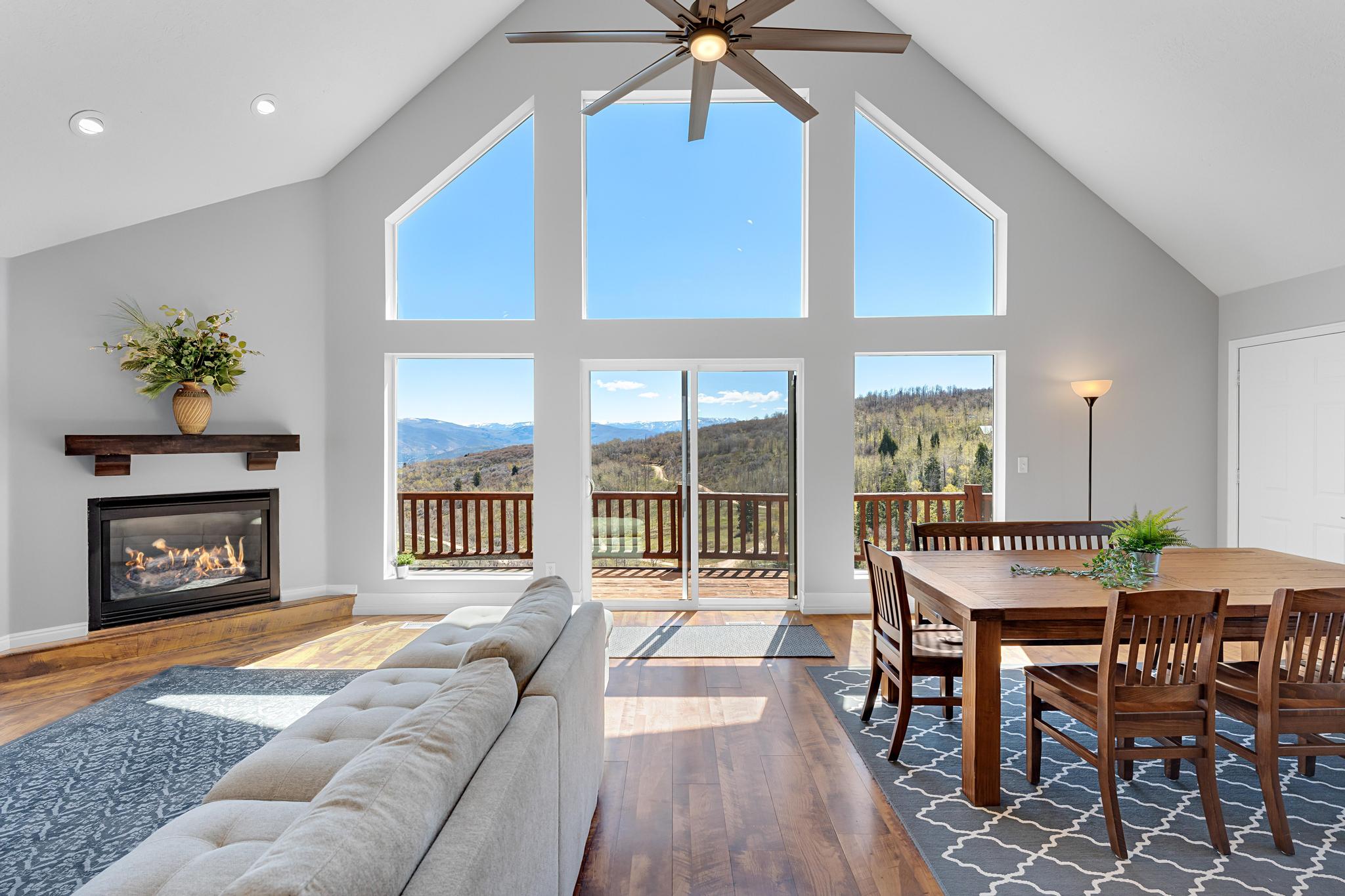 Spacious living area featuring a vaulted ceiling and an integrated ceiling fan