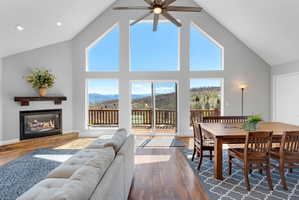 Spacious living area featuring a vaulted ceiling and an integrated ceiling fan